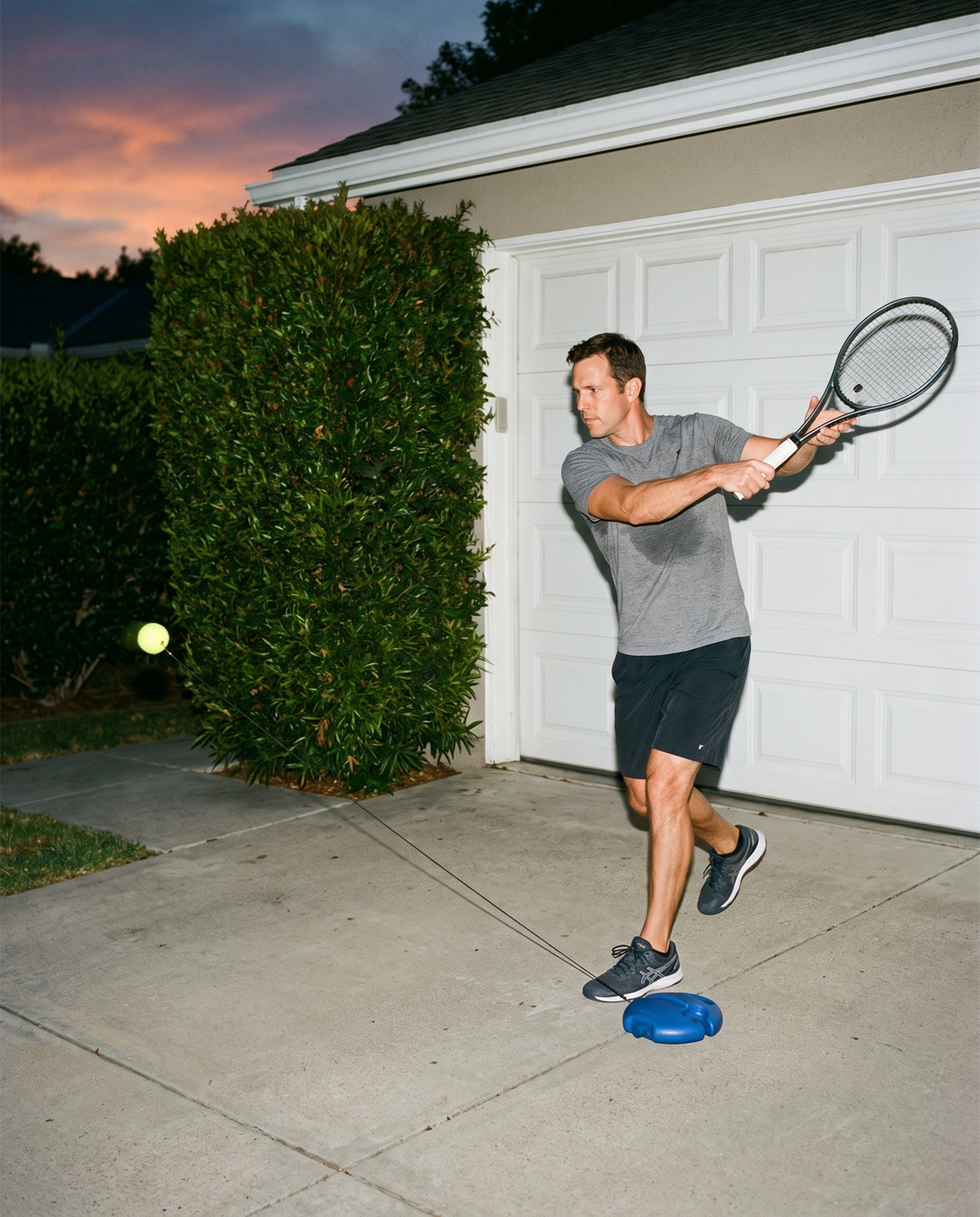 Practicing in a driveway at dusk with the base beside the feet